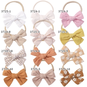 Detail showcasing 12 pieces of baby bow headbands with floral prints and elastic nylon band