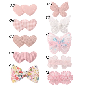 Detail view of pink heart and butterfly hair clips with embroidery and lace textures