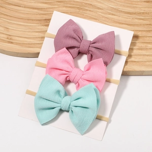 Three-piece baby bow headband set in soft pink and mint green with elastic bands