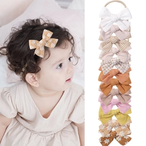Baby bow headband set with 12 elastic nylon bands featuring solid colors and floral patterns