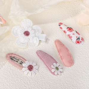 Close-up of cute floral hair clips with embroidery, corduroy and daisy details