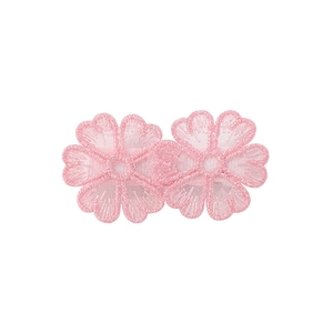 Detailed view of two pink floral lace embroidery patches with fine needlework texture