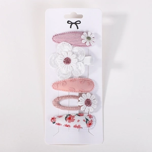 Detailed close-up of 5-piece pink fabric hair clip set with floral embroidery and knits