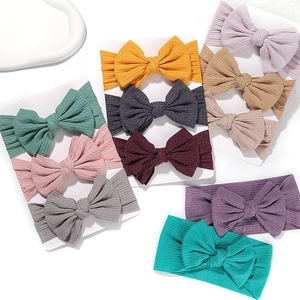 Elastic baby headband set with fabric bows in assorted colors on a minimalist background