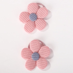 Vue détaillée des élastiques à cheveux fleurs en velours rose avec centres en tricot doux