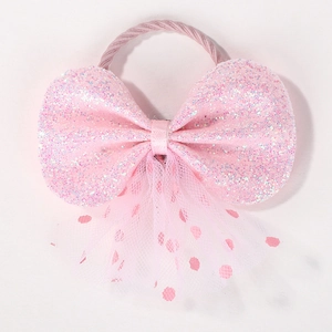 Détail de l'élastique à cheveux nœud rose pailleté avec tulle à pois et sequins