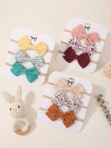 Detailed view of elastic nylon baby headbands with cotton bows on display cards