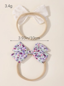 Detail of infant headbands with white textured bow and floral pattern bow on nylon bands