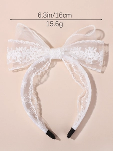 Détail du serre-tête en dentelle blanche avec broderie florale et embouts de protection