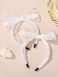 Détail de bandeaux avec nœud en dentelle blanche et bords festonnés pour fillettes