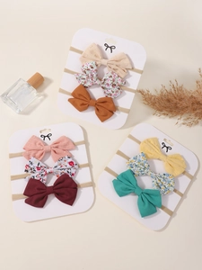 Detail of 9-piece elastic baby headband set featuring solid colors and floral bow designs