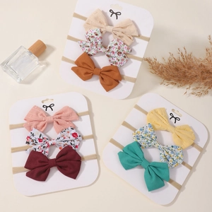 Lot de 9 bandeaux bébé avec nœuds colorés et motifs floraux sur cartes de présentation