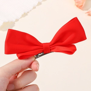 Dettaglio del fiocco in velluto rosso con robusta clip a becco d'anatra in argento