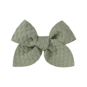 Green jacquard fabric bow hair clip with textured waffle knit pattern for kids