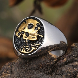 Macro shot of punk style ring featuring golden skull carving on black textured surface