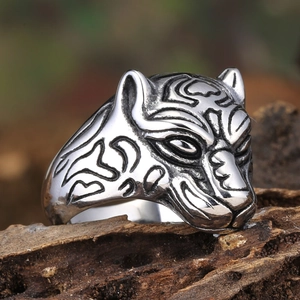 Macro close-up of vintage silver leopard head ring with intricate black textured details
