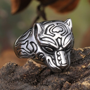 Detail of vintage leopard head stainless steel ring displayed on natural tree bark