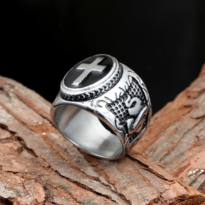 Retro stainless steel cross ring for men with gothic relief on a natural wood surface
