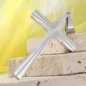 Detail of silver stainless steel cross pendant featuring radial sunray engraved patterns