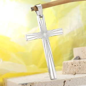 Detailed macro view of silver cross pendant with radial sunburst texture and metal loop