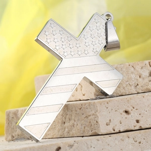 Macro shot of stainless steel cross pendant featuring stars and stripes patterns