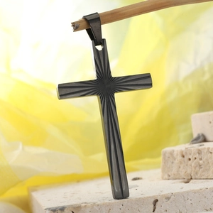 Detailed macro shot of gunmetal cross pendant with radial sunburst engraved texture
