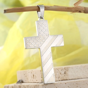 Polished stainless steel cross pendant with US flag stars and stripes on a rustic wood branch
