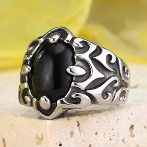 Macro detail of gothic punk men's ring with oval black stone and engraved relief
