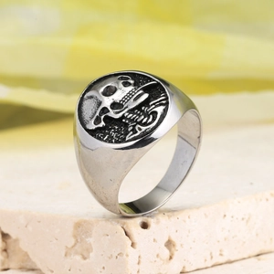 Macro view of vintage silver skull ring with detailed engraving on textured stone