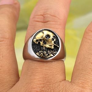 Retro punk titanium steel signet ring with golden skull relief on a black background