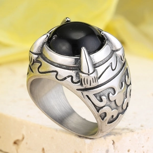 Macro shot of retro dragon claw ring with black stone and detailed metal engravings