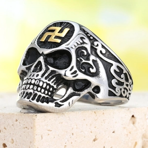 Détail d'une bague tête de mort punk vintage avec symbole doré et gravures ciselées