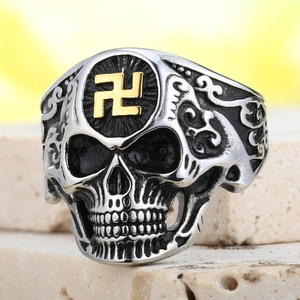Vue macro d'une bague tête de mort en acier punk avec symbole doré et gravures florales