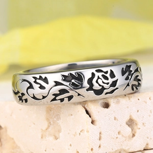 Vintage stainless steel wide band ring featuring rose floral engravings on a rock background
