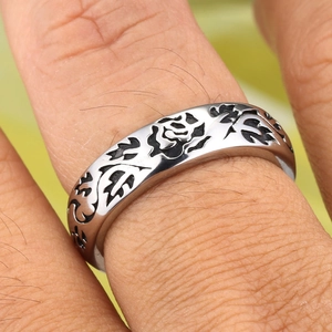 Detailed close-up of a men's titanium steel ring with an embossed rose and leaf pattern