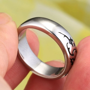 Close-up of titanium steel rose ring for men featuring black tribal etched patterns
