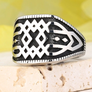 Gros plan d'une bague chevalière pour hommes avec motif géométrique et texture vintage