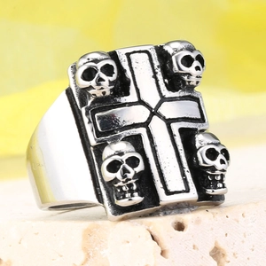 Macro shot of vintage skull and cross steel ring on white textured stone background