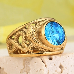 Vintage punk titanium steel ring with a large round blue gemstone and ornate gold-tone band