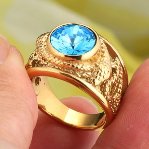 Detailed close-up of a vintage gold ring featuring a large blue gemstone and scale texture