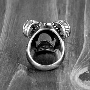 Macro shot of a vintage ram head ring made of stainless steel on dark wood