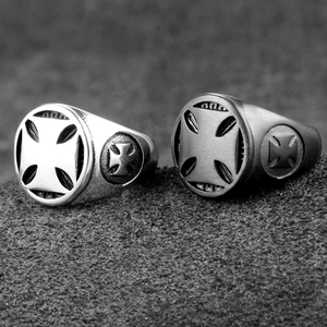 Close-up of matte black and polished silver stainless steel rings with embossed iron cross