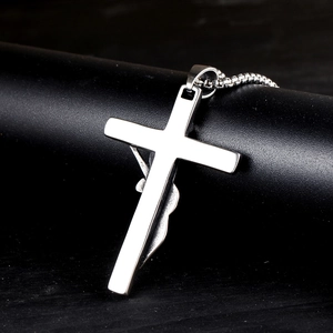 Detailed view of religious crucifix pendant with Jesus relief and stainless steel box chain
