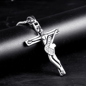 Macro shot of polished steel cross guitar pendant with sparkling white zircon stones