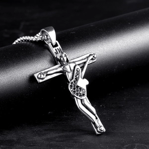 Macro detail of punk rock gothic cross guitar pendant with black zircons on chain