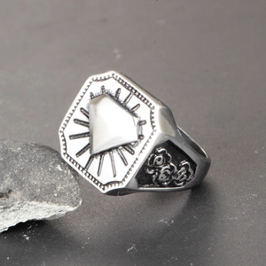 Détail d'une bague chevalière vintage avec gravures de roses et design géométrique poli
