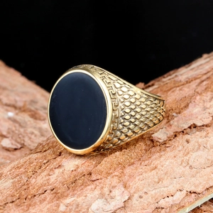 Macro shot of gold-plated vintage ring with black onyx inlay and Greek key carvings