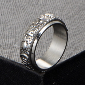Macro view of vintage engraved spinner ring with floral patterns and letter B