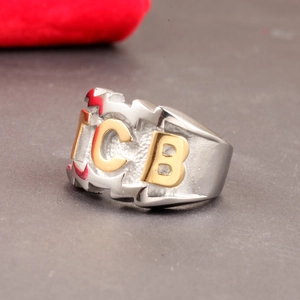 Detail of wide punk silver ring with gold ICB letters and red lightning bolt symbols