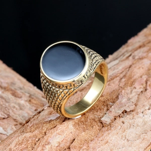 Macro shot of gold-plated signet ring with black enamel inlay and Greek key details